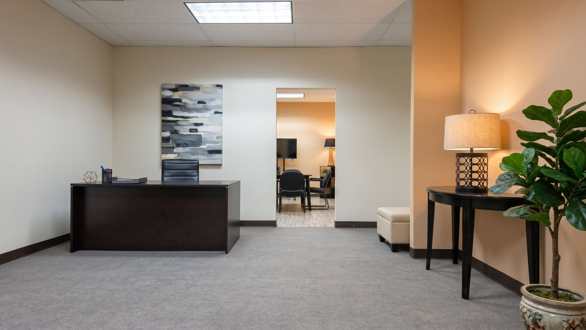Reception area with desk, waiting seating and an opening to the meeting room